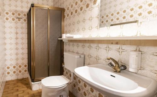 a bathroom with a sink and a toilet and a mirror at Hotel Pinzgauerhof - Inclusive Evening Dinner in Saalbach Hinterglemm