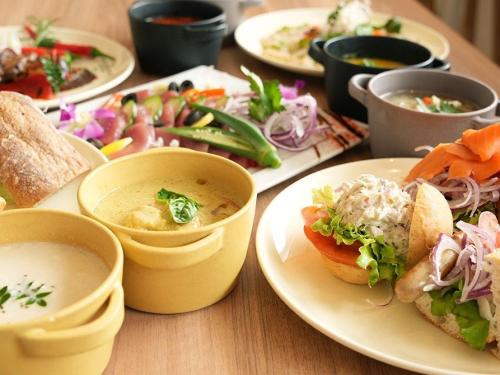 石垣岛The BREAKFAST HOTEL MARCHE Ishigaki Island的摆满食物和汤碗的桌子