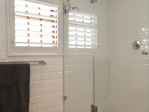 een badkamer met een douche en een glazen deur bij 40 on Longmarket in Stanford