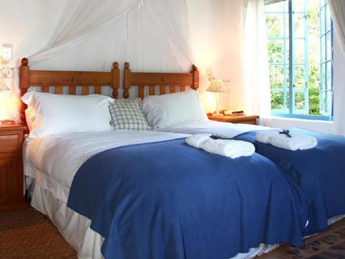 a bedroom with a large bed with blue sheets at Lavender’s Blue in Stanford