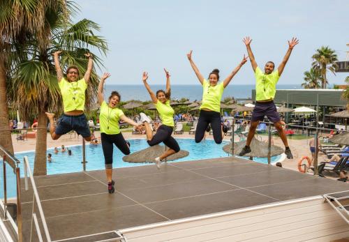 a group of people jumping on a trampoline at a pool at Ilunion Calas de Conil in Conil de la Frontera