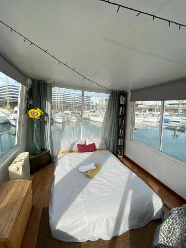 1 cama blanca grande en una habitación con ventanas en The Floating Home en Barcelona