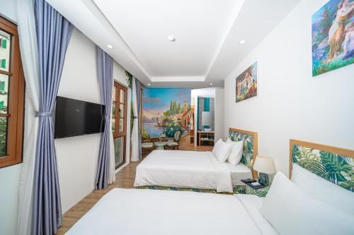 a bedroom with two beds and a flat screen tv at Cybele Sunset Hotel Phu Quoc in Phu Quoc