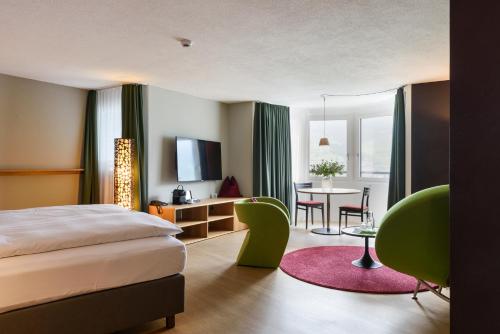 ザルネンにあるSeehotel Wilerbad Spa & Seminarのベッドとテーブルが備わるホテルルームです。