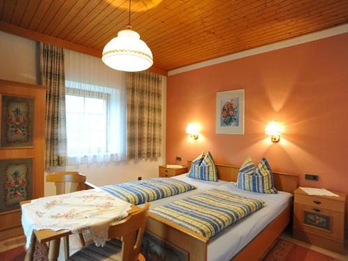 Un dormitorio con una cama y una mesa. en Ferienhaus Nickl, en Weissbriach