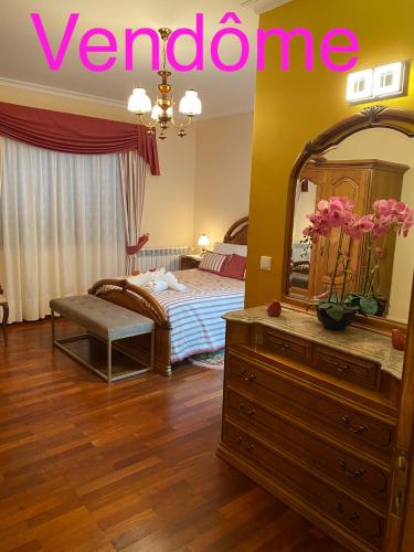 a bedroom with a bed and a dresser with a mirror at Residência Vitória de São Marcos in Trancoso