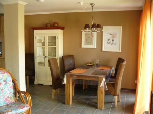 - une salle à manger avec une table et des chaises en bois dans l'établissement Ferienhaus Ambiente, à Harlesiel