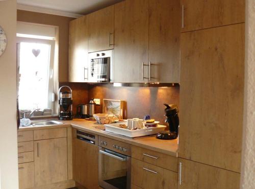 - une cuisine avec des placards en bois et un comptoir dans l'établissement Ferienhaus Ambiente, à Harlesiel