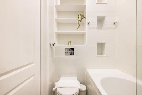 Baño blanco con aseo y lavamanos en The Chelsea Collection en Londres