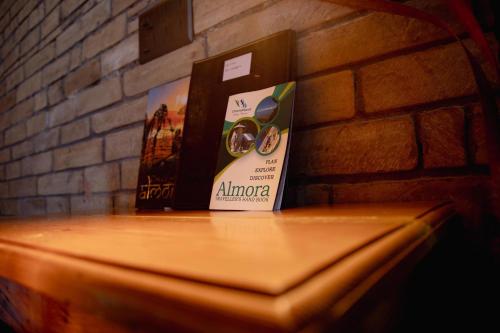 a book sitting on top of a table next to a brick wall at Kasar Himalaya Holiday Resort, Binsar Rd in Almora