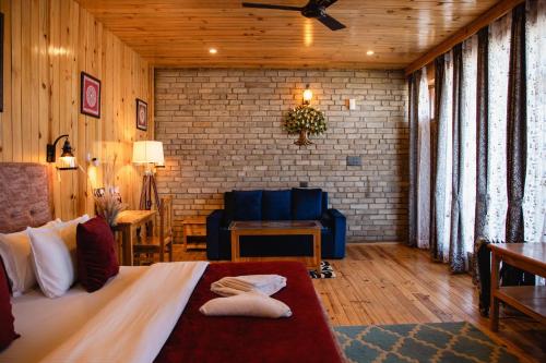 a bedroom with a bed and a couch in a room at Kasar Himalaya Holiday Home, Binsar Rd in Almora