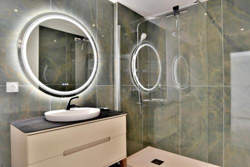 uma casa de banho com um lavatório e um espelho em L Ostra 1 em Cancale