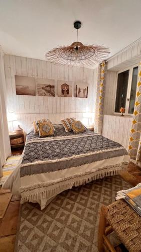 une chambre avec un grand lit et un lustre dans l'établissement Bergerie à quelques minutes du centre de Grimaud, à Grimaud