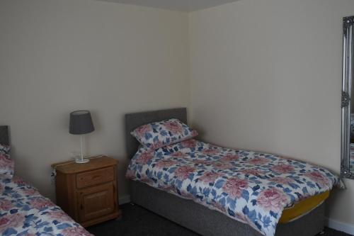 a small bedroom with a bed and a night stand at 4 Woodyard Cottages, 2 Bedroom with free parking. in Long Sutton