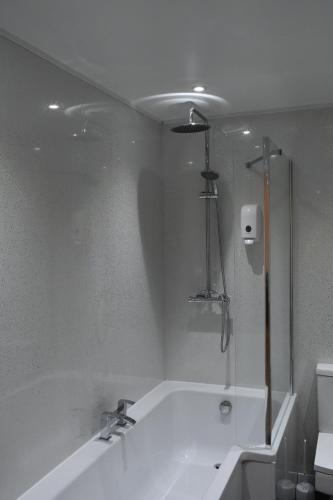 a white bathroom with a tub and a shower at 4 Woodyard Cottages, 2 Bedroom with free parking. in Long Sutton