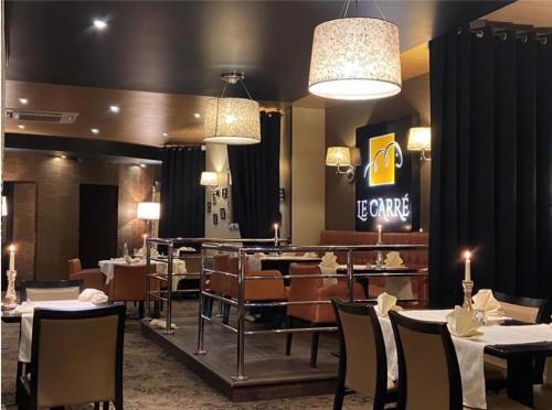 カンブレーにあるLogis Hôtel & Restaurant - Le Mouton Blancのレストラン内のダイニングルーム(テーブル、椅子付)