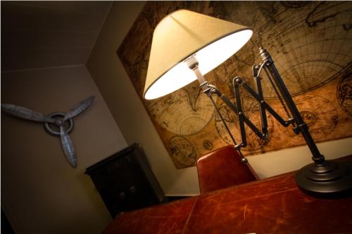 une lampe au-dessus d'un bureau avec un globe sur le mur dans l'établissement Logis Hôtel & Restaurant - Le Mouton Blanc, à Cambrai