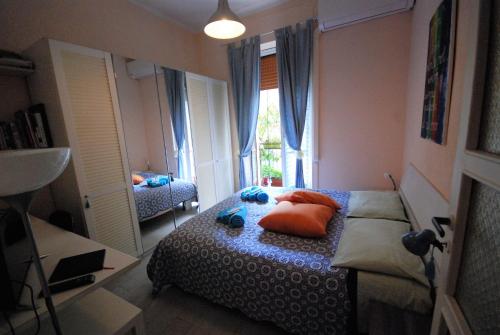 - une chambre avec un lit doté d'oreillers orange et une fenêtre dans l'établissement Lovely 1-Bedroom Apartment in Lingotto Area, à Turin