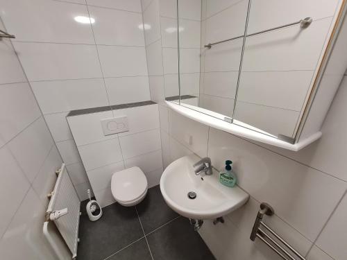 a white bathroom with a sink and a mirror at Schöne helle Wohnung in Malsch in Malsch