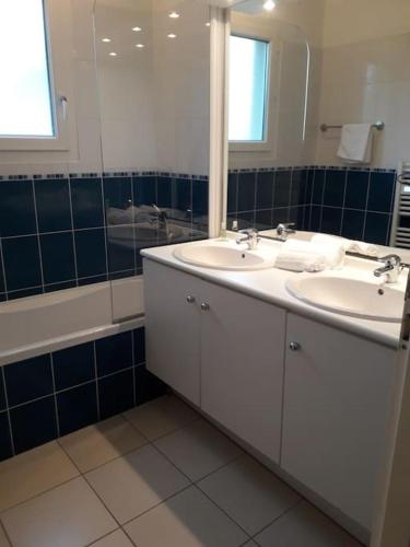 une salle de bain avec deux lavabos, un miroir et une baignoire dans l'établissement Studio dans une résidence calme - 9544, à Soulac-sur-Mer