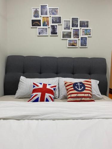 1 cama con 2 almohadas y cuadros en la pared en sky suite klcc, en Kuala Lumpur