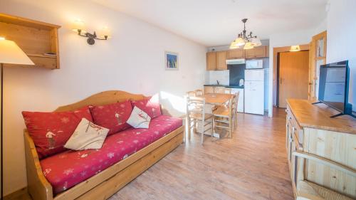 un salon avec un canapé rouge et une cuisine dans l'établissement B305- Appartement 2 pieces cabine 6 personnes, à Orcières