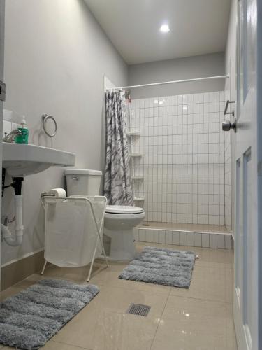 ein Badezimmer mit einem WC und einer Dusche mit Teppichen in der Unterkunft A modern townhouse at Farm in Georgetown