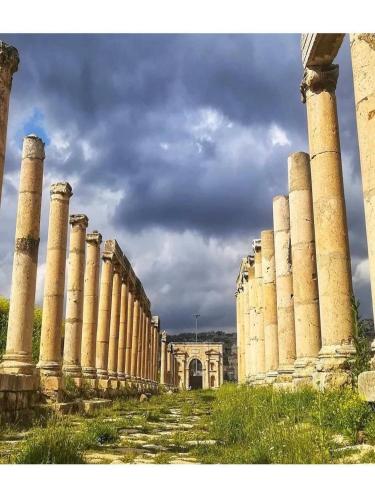 una fila de columnas delante de un edificio en White tulips apartment الزنبقة البيضاء, en Jerash