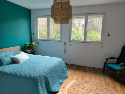 1 dormitorio con 1 cama azul y 2 ventanas en Chambre d'hôte proche de la nature, en Lamorlaye