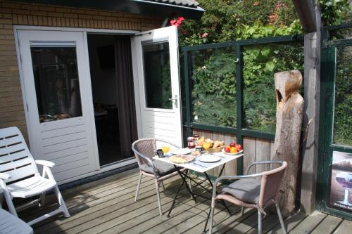 un patio avec une table et des chaises sur une terrasse dans l'établissement Bed & Breakfast Klokgaaf, à De Koog