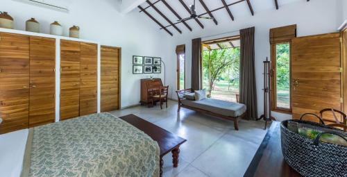 ein Schlafzimmer mit einem Bett und einem Stuhl darin in der Unterkunft Nyne Hotels - Mayur Lodge, Yala in Yala