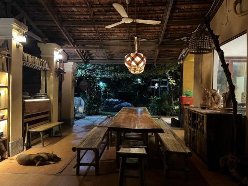 a dining room with a table and a dog laying on the floor at Lagom Village (Glamping Site) in Hanoi