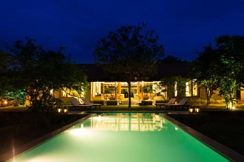 a swimming pool in front of a house at night at Nyne Hotels - Mayur Lodge, Yala in Yala