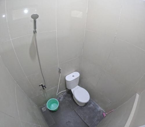 a bathroom with a toilet and a green bowl at GKR J8 Homestay Jogja in Pedes
