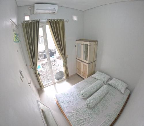 a small bedroom with a bed and a window at GKR J8 Homestay Jogja in Pedes