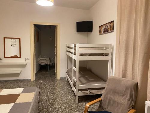 a bedroom with a bunk bed and a room with a chair at La dimora nonna Eugy in Polignano a Mare