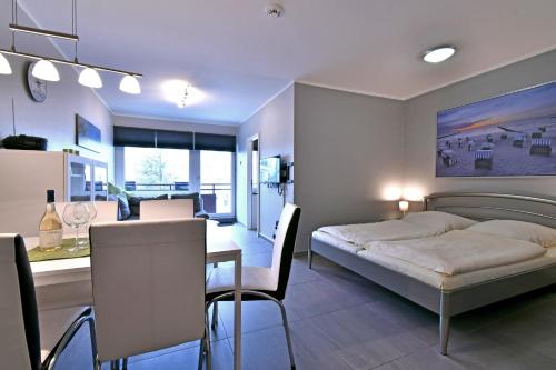 1 dormitorio con cama, mesa y cocina en RES 408 - Residenz - Teilseeblick en Scharbeutz