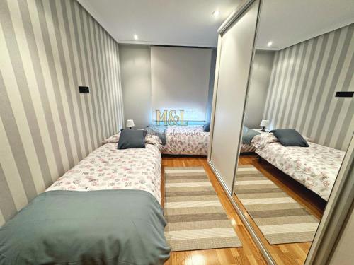 a room with two beds and a mirror at De Cine in Oviedo