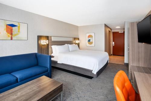 ベルビルにあるHoliday Inn Express Hotel & Suites - Belleville Area by IHGのホテルルーム(ベッド1台、青いソファ付)