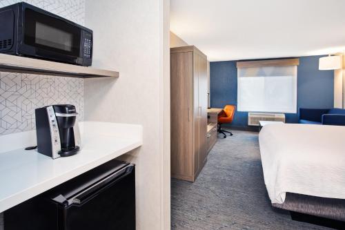a small room with a kitchen and a living room at Holiday Inn Express Hotel & Suites - Belleville Area by IHG in Belleville
