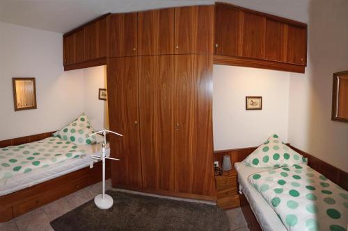 a bedroom with two beds and a wooden cabinet at TER 304 - Terrassenhuegel -Teilseeblick in Scharbeutz