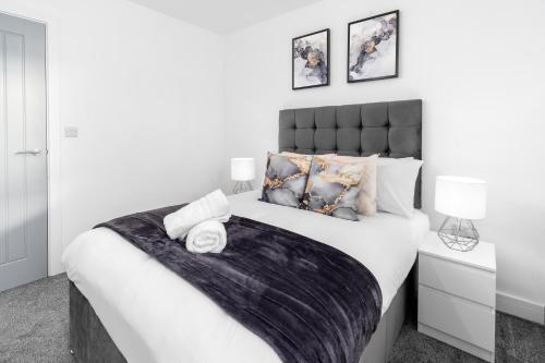 a white bedroom with a large bed with pillows at Stylish Apartment - 2 Bedrooms - Balcony - Parking - Netflix - Wifi - 7MC in Birmingham