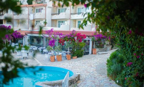a courtyard with tables and flowers and a building at Bougainville Bay Apartments in Sarandë