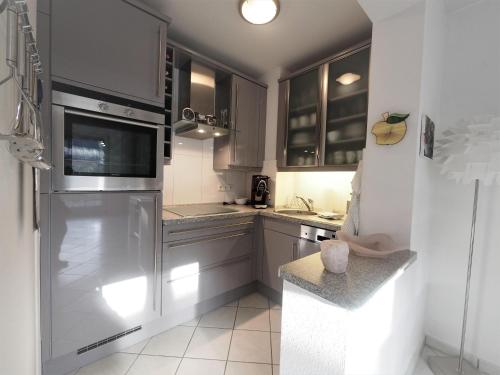 a kitchen with stainless steel appliances and gray cabinets at Aal 6EG in Haffkrug