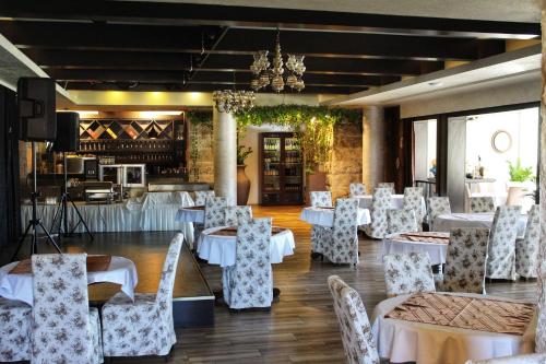 une salle à manger avec des tables et des chaises blanches dans l'établissement Hotel Opera Jaz, à Budva
