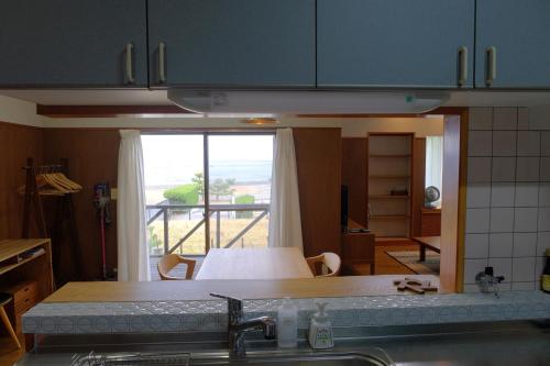 a kitchen with a sink and a view of a room at ワタリグラスハウス in Gamō