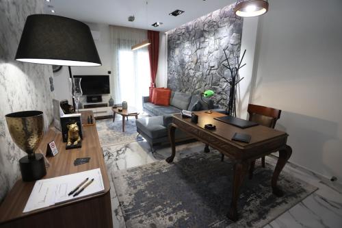 a living room with a table and a couch at LA Larissa Luxury Apartments Kreousa in Larisa
