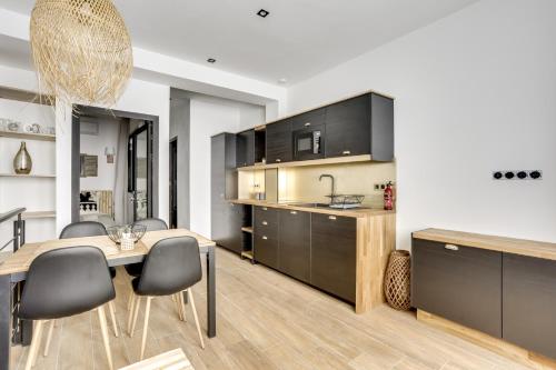 kuchnia i jadalnia ze stołem i krzesłami w obiekcie 149 Suite Christophe - Superbe Appartement à Paris w Paryżu