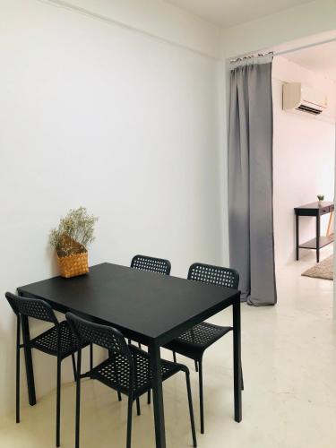 una mesa de comedor negra y sillas en una habitación en Homies.Bkk, en Bangkok