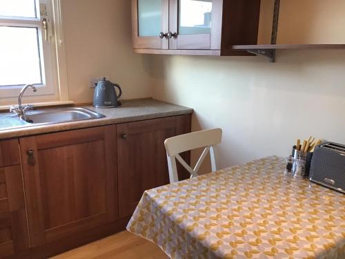 een kleine keuken met een tafel en een wastafel bij Comelybank Guesthouse in Crieff